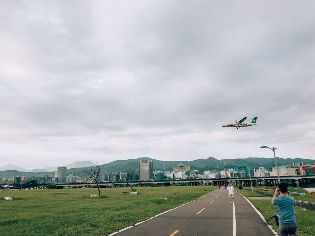 View of airplane landing at Songshan Airport while riding Ubike in taipei